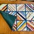 Handcrafted American folk art patchwork quilt featuring diagonally pieced blocks arranged in a grid, creating a bold...