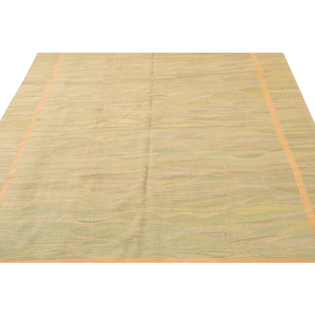 This contemporary Turkish Kilim rug, crafted in the 21st century, showcases an elegant beige and green foundation adorned...