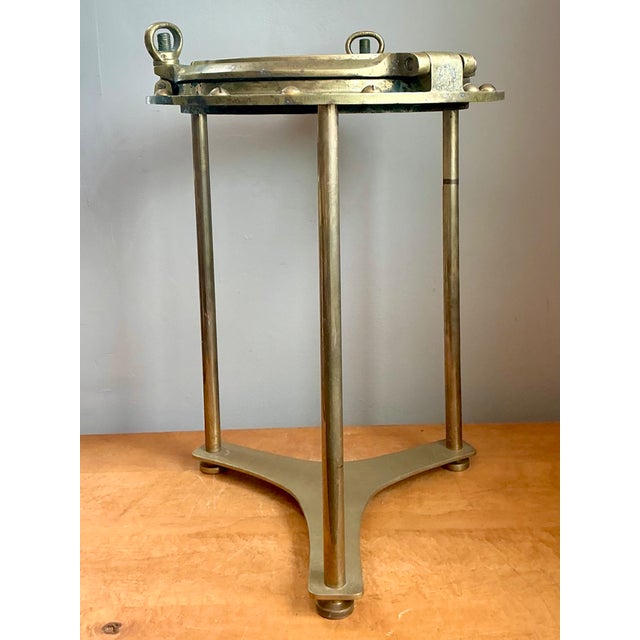 This distinctive vintage maritime accent table brings authentic nautical character to the interior with its brass...