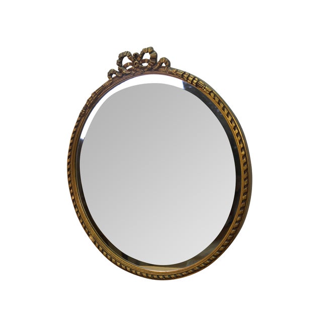 Mid century round beveled bathroom / wall / vanity mirror featuring a Neoclassical ribbon, rope and tassel design....