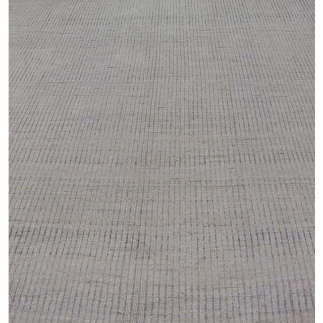 Measures: 9'2 x 11'9. This modern casual tribal rug has been hand-knotted in wool. The rug features a modern geometric...