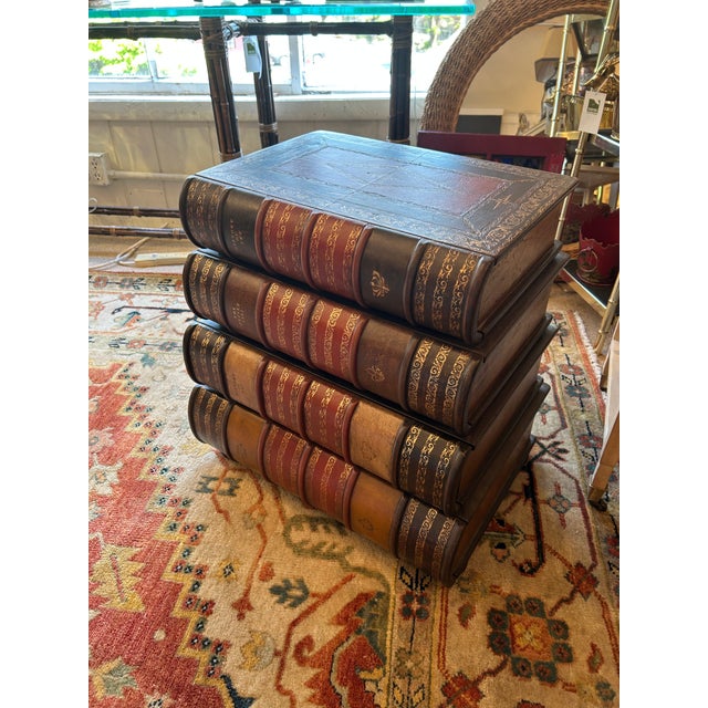 Eye catching side table chest of drawers that looks like oversized stacked embossed leather books having 4 graduated...