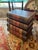 Eye catching side table chest of drawers that looks like oversized stacked embossed leather books having 4 graduated...