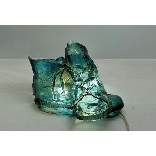 Rare resin table lamp produced by L'isola che non c'è in the 1970s. Made of resin in the shape of shoes, with the brand...