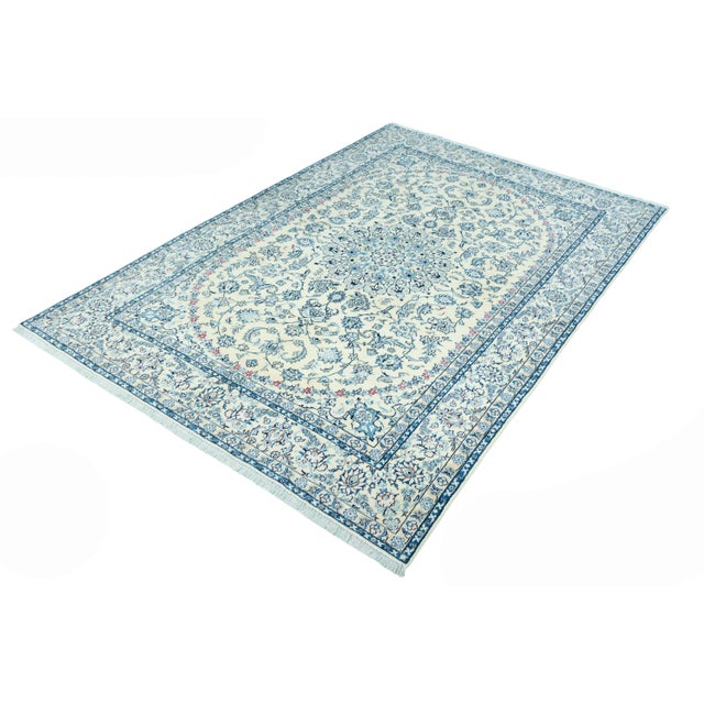 An exquisite hand-knotted Nain 9 La oriental rug with fine floral patterns and an artistic medallion design. The elegant...