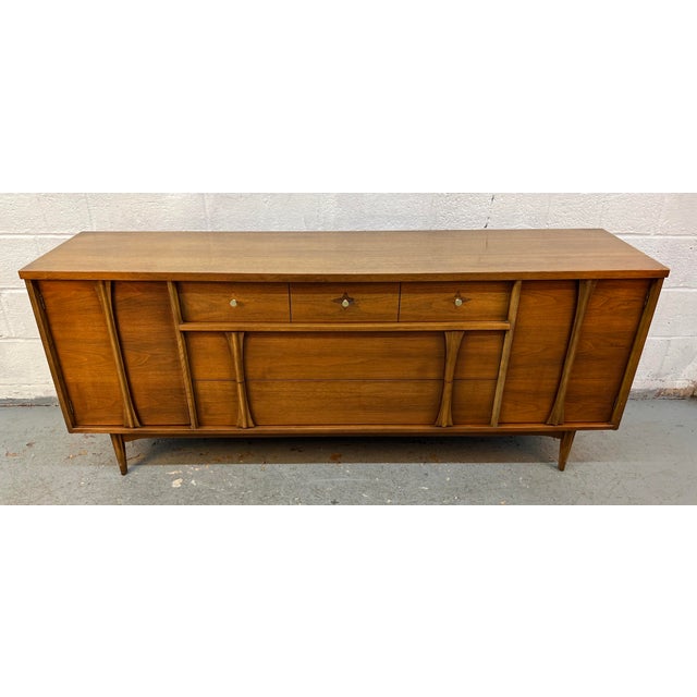 Bring iconic mid-century style into your home with this beautifully designed walnut credenza by renowned designer Leo...