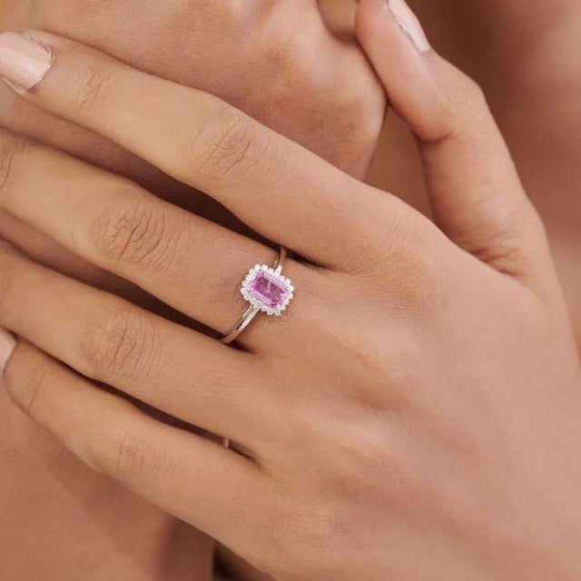 This Art Deco-style ring features a 0.8 ct emerald-cut pink sapphire, set in 14k white gold. The center stone measures 6.5...