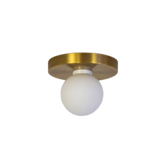 Minimal from top to bottom. This black flush mount pairs a metal base with a soft glass globe. Cool, calm, and quietly...