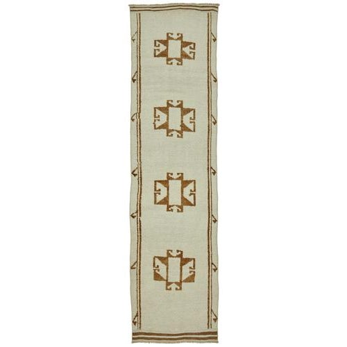 This exquisite runner rug is a rare example of tribal craftsmanship, hand-knotted by the women of the Herki tribe during...