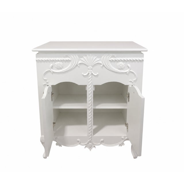 The upper part of the cabinet features signature hand-carved shell, floral, and scrollwork patterns, accompanied by a...