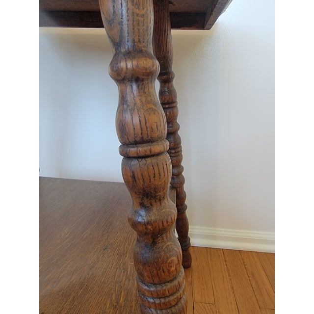 Antique square oak parlor, lamp, or occasional table dating to the early 20th century. The design combines a substantial...