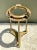 This vintage brass and glass porthole accent table channels nautical maritime design, its round glass top set securely...