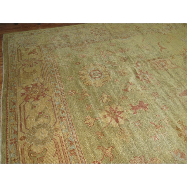One of a kind traditional wool 21st century Turkish Oushak in muted green and gold tones, accents in brick red Measures:...