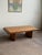 Striking postmodern coffee table in oak with distinctive waterfall edges and substantial block legs. The low, wide...
