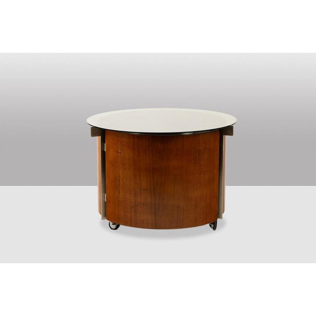 Eugenio Gerli, for Tecno. Round coffee table with built-in swivel bar section, made of curved teak and brushed aluminum....