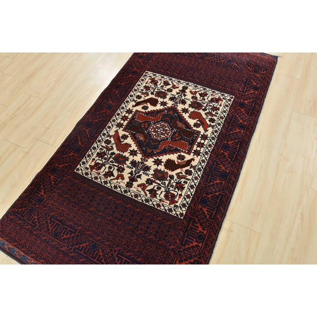 An authentic vintage tribal Baloch rug hand-knotted with fine wool and natural dyes. This nomadic oriental rug features a...