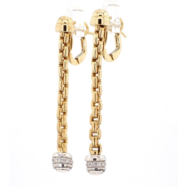 Italian-made 14K yellow gold drop earrings feature a 6.3mm diamond-set ball suspended from a delicate chain with a secure...