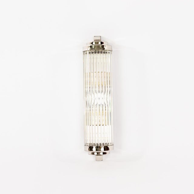 The Art Deco wall lamp B combines classic elegance with high-quality craftsmanship. Made from clear glass rods and encased...