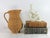 Vintage woven wicker pitcher with handle. No makers mark. Some age wear.