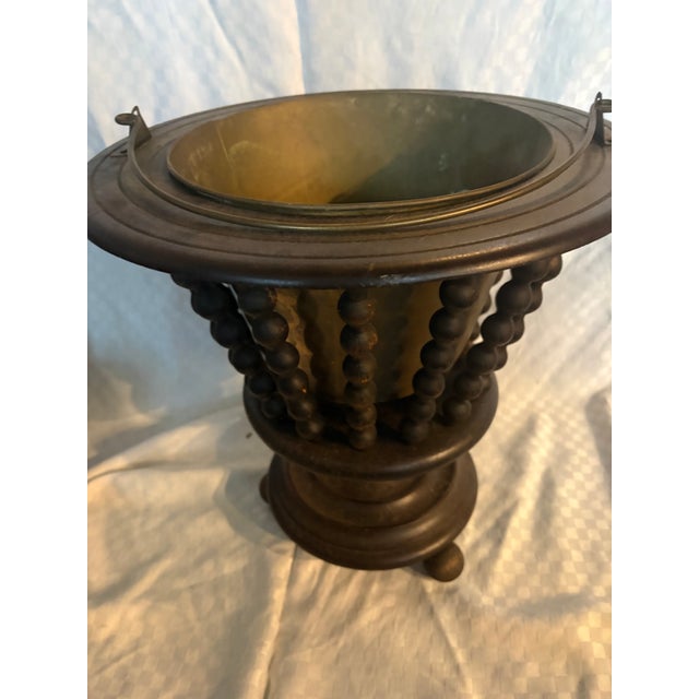 A Dutch walnut wine bucket with brass liner and turned spindles. The piece dates to the 1840's and is also known as a...