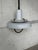 This white pendant light features a layered saucer shade with contrasting black accents, casting downward illumination....