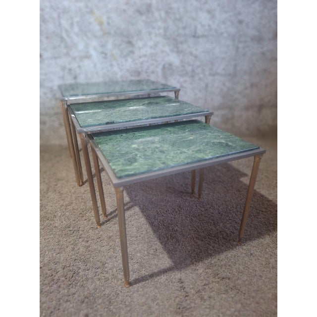An elegant set of three French nesting tables dating from the 1970s, crafted in the style of the prestigious Maison...