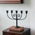 A dramatic five-arm iron candelabra with curled scrollwork, hammered texture, and a wonderfully timeworn blackened patina.