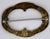 A handsome antique brass brooch with repose flourishes and floral design all around. There is a maker's mark that is hard...