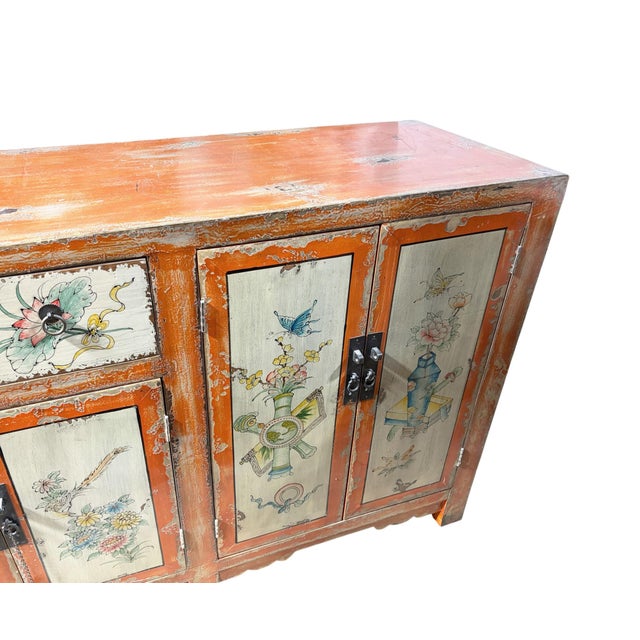 Superb fine Mongolian cabinet, circa 1930, featuring light distressed salmon-color doors and drawers hand-painted with...