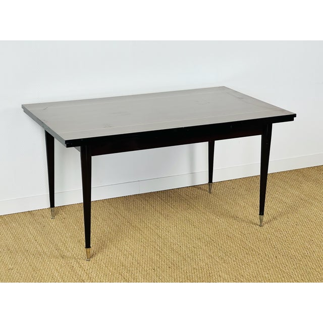 A french art deco dining table dating from the 1960s, featuring two extension leaves. this elegant extendable table,...