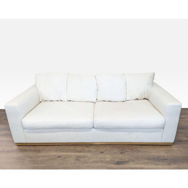 This West Elm 3-seat sofa features a clean and modern design in a neutral cream color. The couch offers deep, comfortable...