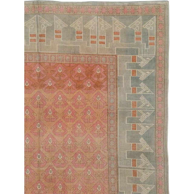 This Mid-20th century Turkish Anatolian room-size carpet presents an ordered composition centered on a coral field filled...