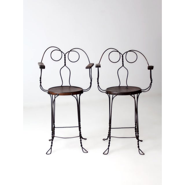 This pair of antique wire bar stools by A.H. Andrews & Co. of Chicago dates to circa 1900–1915. The dark steel wire frames...