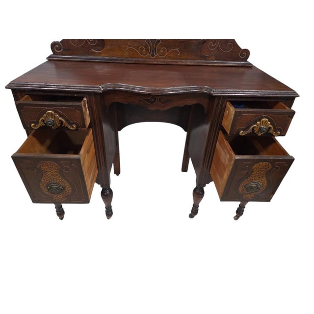 Elegant antique Victorian vanity featuring intricate inlay work and a beautifully shaped tri-fold mirror. Crafted from...