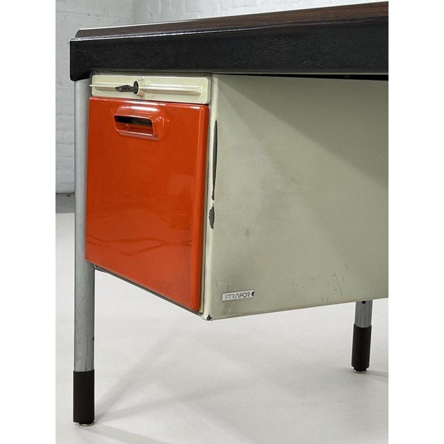 A substantial 1950s desk with double drawers and orange ABS fronts, reminiscent of the work of Marc Held, here in...