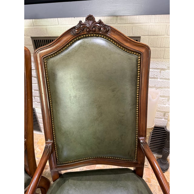 This traditional Louis XV-style carved wood armchair features rich olive green leather upholstery, tapestry upholstery...