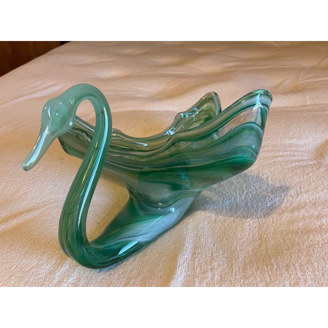 This decorative glass piece is a hand-blown swan-shaped centerpiece bowl created in the Murano style, likely dating from...