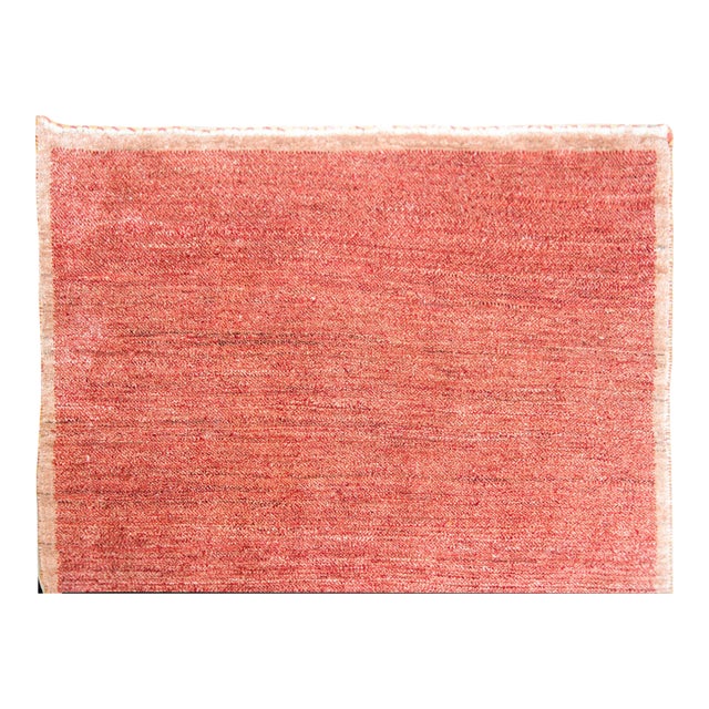 A serene late 20th century Tibetan hand-knotted rug with a weathered cranberry and brown field surrounded by a thin brown...