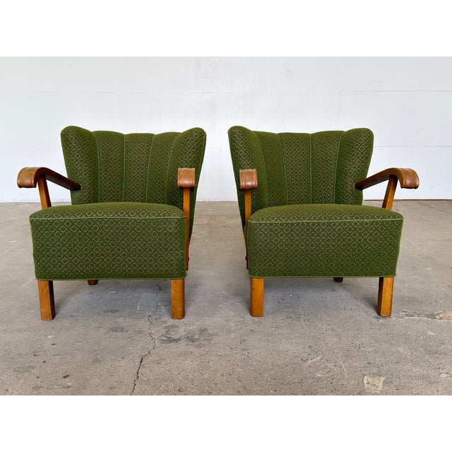 A matched pair of oak lounge chairs in the Danish Modern tradition, upholstered in an original green patterned wool and...