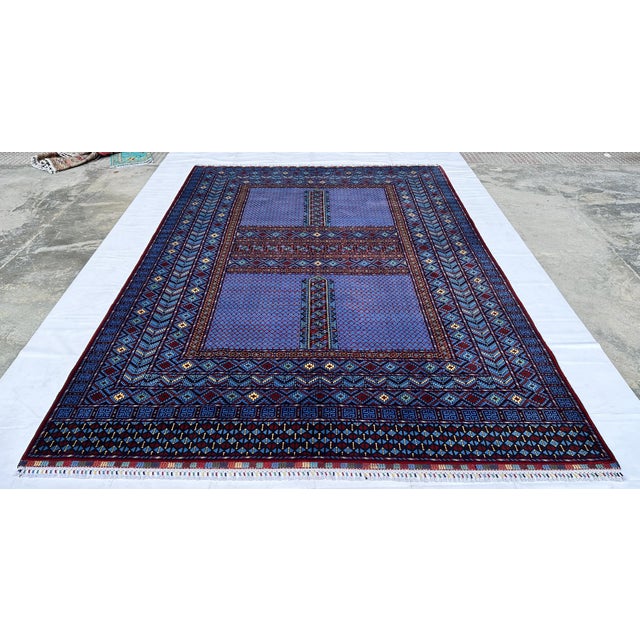 This exceptional hand-knotted wool area rug showcases a traditional Afghan Turkmen Ensi (Hachlu) pattern. The center field...