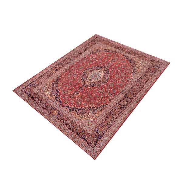 This hand-knotted wool rug features a traditional medallion pattern in red and blue, adding a touch of elegance to any...