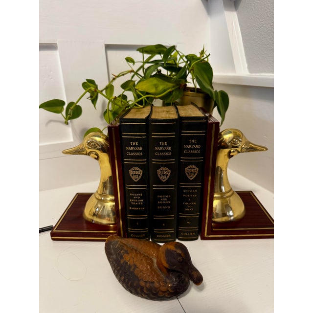 A sculptural and charming pair of vintage brass duck head bookends, mounted on rich wood bases with subtle gold trim....