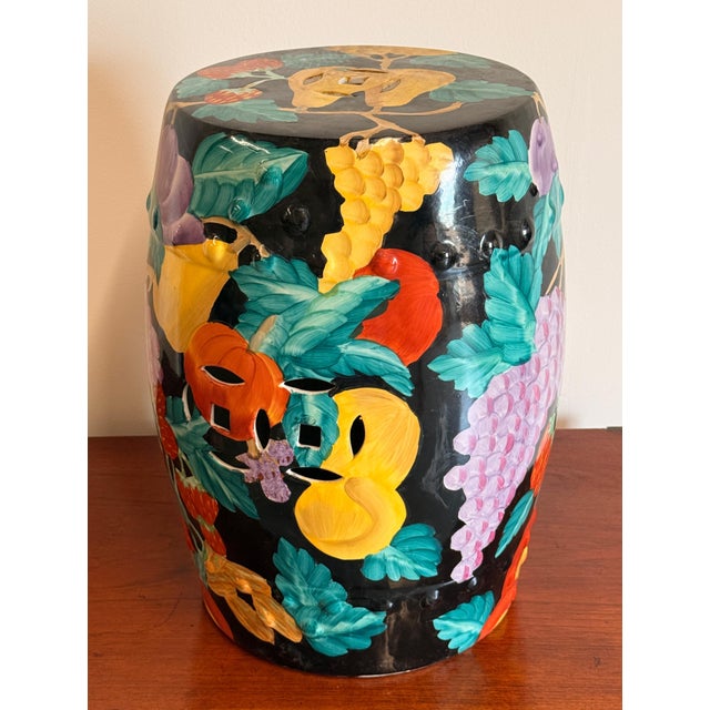 This barrel-form garden seat is decorated all over with a dense, exuberant arrangement of fruit in relief against a black...