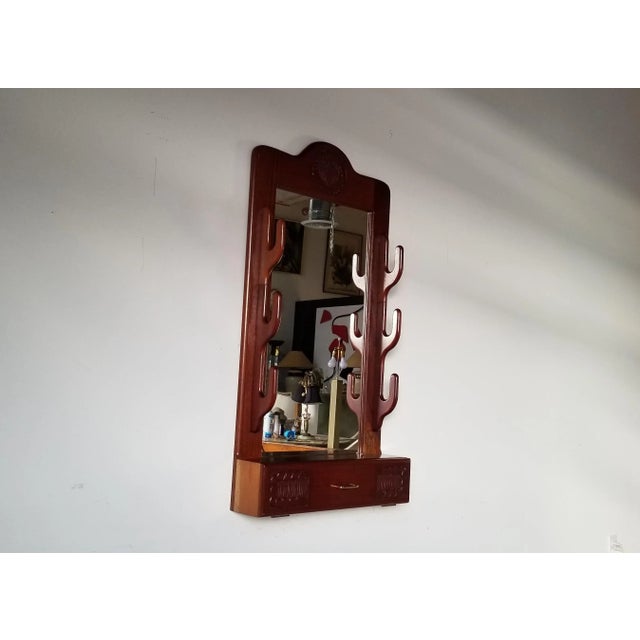 Offered for sale is a whimsical Vintage handmade solid mahogany wood wall mirror. Features, carved wood details, one shelf...