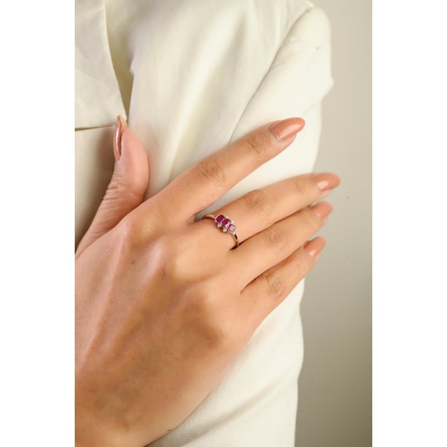 This elegant three-stone ring features three vibrant natural oval-cut rubies totaling 0.54 carat, beautifully set in 14k...