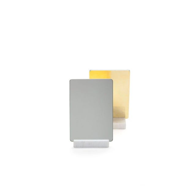 This vanity mirror is composed of two parts: a base of Carrara marble and a mirror that can be placed vertically or...