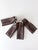A set of four vintage 1950s golf club head covers in rich brown and cream, accented with metallic gold piping and...