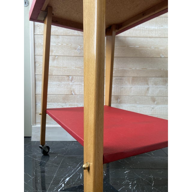 Vintage Mid-Century Modern rolling side table / bar cart from the 1960s, featuring a bold red top and lower shelf paired...