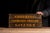 Illuminated brass teller sign with three stacked panels reading "CHECKING," "CASHIERS CHECKS," and "SAVINGS," each cut...