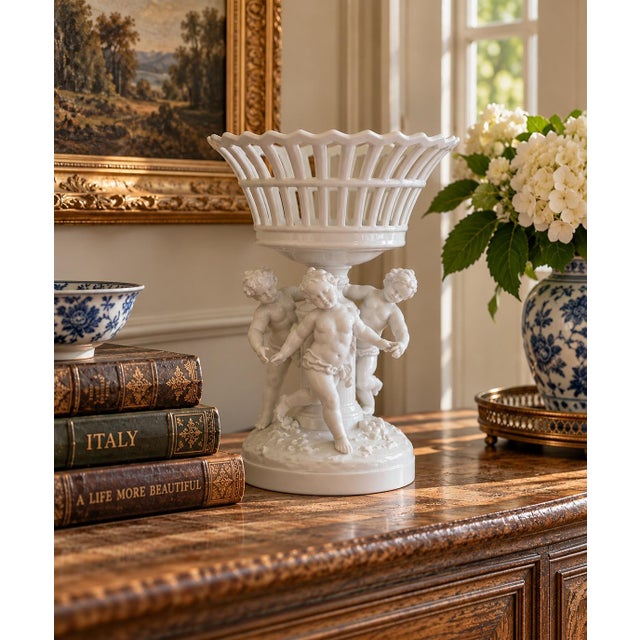 A refined reticulated porcelain basket executed in a neoclassical idiom with delicate openwork, raised on a pedestal...